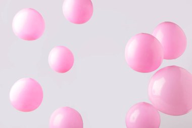 Gri arka planda pembe pastel balonlar. Minimalizm. Üst görünüm