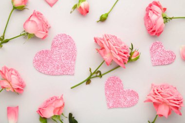 Gri arka planda kalpleri olan parlak pembe güller. Bahar konsepti Üst görünüm