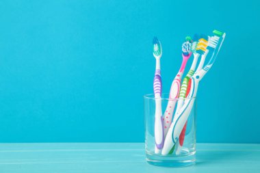 Mavi arka planda cam kaplı diş fırçaları. Üst görünüm
