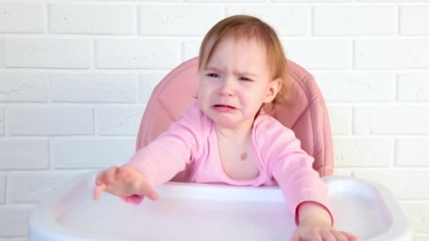 Uma Menina Chora Enquanto Está Sentada Uma Cadeira Alta — Vídeo de Stock