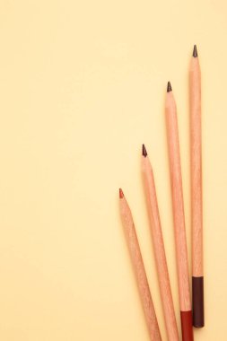 Bej renkli pastel arka planda renkli kalemler. Üst görünüm.