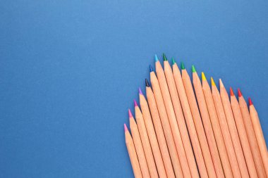 Mavi arka planda renkli kalemler. Üst görünüm.