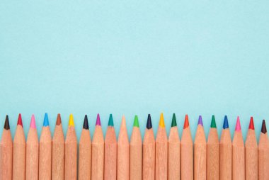 Mavi arka planda renkli kalemler. Üst görünüm.