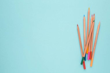 Mavi arka planda renkli kalemler. Üst görünüm.