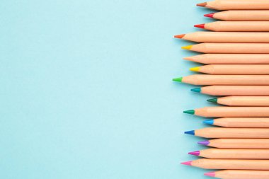 Mavi arka planda renkli kalemler. Üst görünüm.