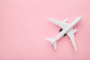 Pembe pastel arka planda model uçak. Seyahat kavramı