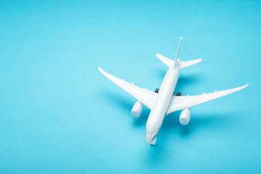 Mavi pastel arka planda model uçak. Seyahat kavramı