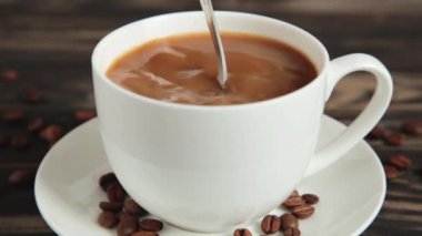 Kahveyi kaşıkla karıştıran kişinin üst görüntüsü