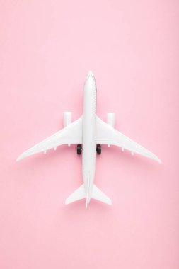 Pembe pastel arka planda model uçak. Seyahat kavramı