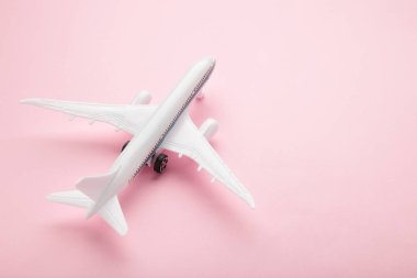 Pembe pastel arka planda model uçak. Seyahat kavramı
