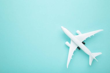 Mavi pastel arka planda model uçak. Seyahat kavramı