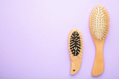 Mor arka planda tarak ve saç fırçası seti. Üst görünüm