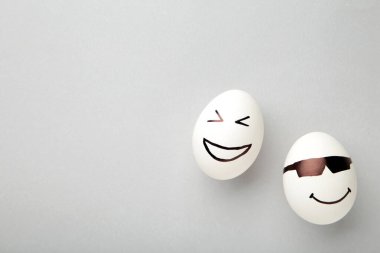 Komik Paskalya yumurtaları, gri arka planda farklı duyguları var. Fotokopi alanı olan paskalya kompozisyonu. Üst görünüm