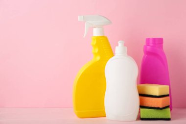 Pembe arka planda temizlik aletleri. Üst görünüm