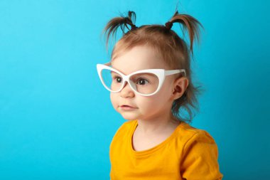 Güneş gözlüklü, mavi gözlüklü ve fotokopi alanı olan güzel mutlu küçük kızın portresi. Üst görünüm