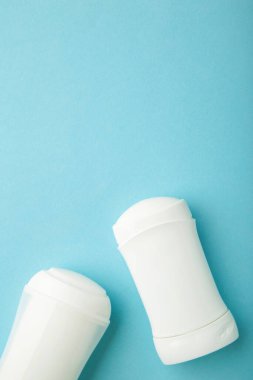 Mavi arka planda beyaz terleme önleyici deodorant. Deri bakımı konsepti. kopyalama alanı. Dikey foto
