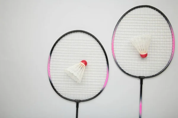 Shuttlecocks and badminton rackets on grey background. Top view.