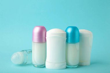 Mavi arka planda farklı deodorantlar, üst manzara. Cilt bakımı. Üst görünüm