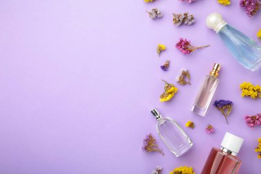 Mor arka planda çiçekli bir şişe parfüm. Üst görünüm