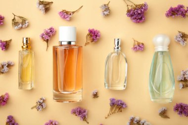 Bej arka planda çiçekli bir şişe parfüm. Üst görünüm