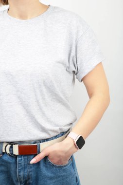 Gri arka planda gri tişörtlü genç kız. Tişört tasarımı ve insanların konsepti. Yakın çekim. Üst görünüm.