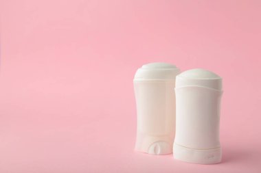 Pembe arka planda beyaz terleme önleyici deodorant. Deri bakımı konsepti. Boşluğu kopyala, üst görünüm.