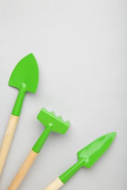 Gri arkaplanda fotokopi alanı olan bahçe aletleri. Üst görünüm