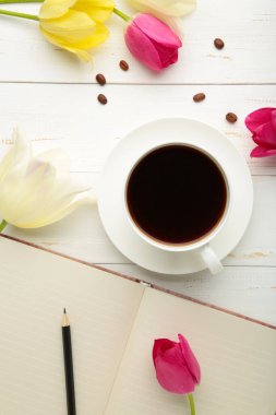 Arka planda kahve ve lalelerle dolu bir defter. Üst görünüm