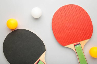 Pinpon raketleri ve top gri arka planda. Üst görünüm