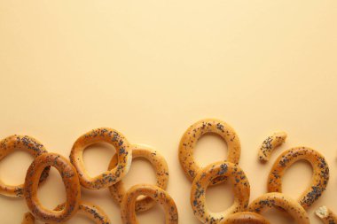 Bej arka planda haşhaş tohumlu tam simit. Üst görünüm