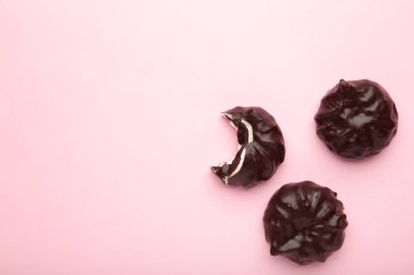 Pembe arka planda çikolata kaplı marşmelov. Üst görünüm