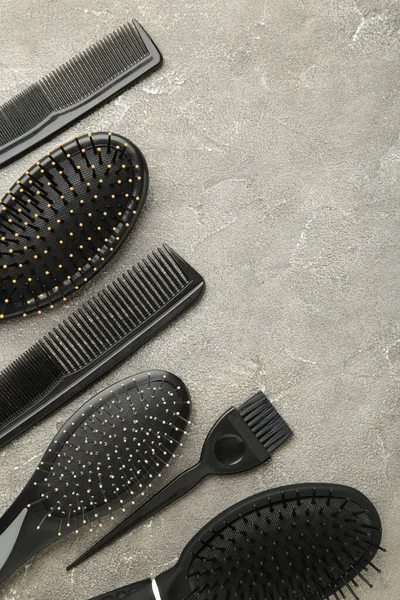 Hair tools, beauty and hairdressing concept - different brushes or combs on grey background. Top view