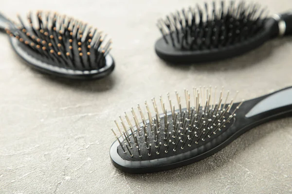 Hair tools, beauty and hairdressing concept - different brushes or combs on grey background. Top view