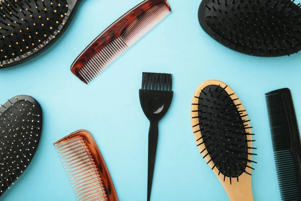 Hair tools, beauty and hairdressing concept - different brushes or combs on blue background. Top view