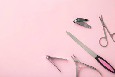 Pembe arka planda bir manikür seti. Üst görünüm