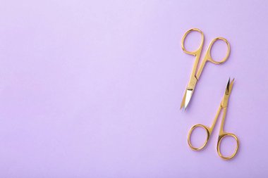 Mor arka planda manikürlü kadın tırnakları için makas. Üst görünüm