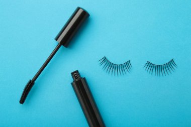 Mavi arka planda siyah kirpik ve rimel. Üst Manzara. Güzellik konsepti