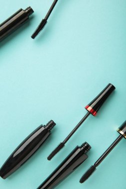 Nane arkaplanında siyah rimel asası ve fotokopi alanı olan bir tüp. Dikey fotoğraf. Üst görünüm