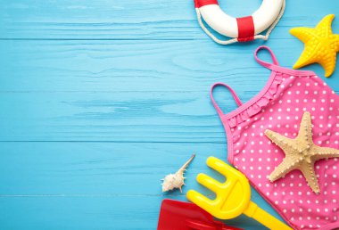 Mavi arka planda aksesuarları olan yaz plaj oyuncakları. Üst görünüm