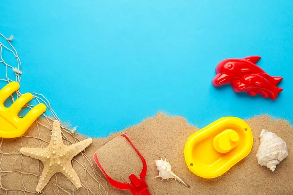 Mavi arka planda aksesuarları olan yaz plaj oyuncakları. Üst görünüm