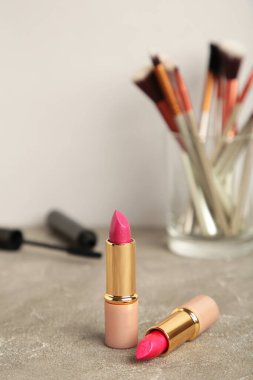 Gri arka planda makyaj ürünleri seti. Üst görünüm