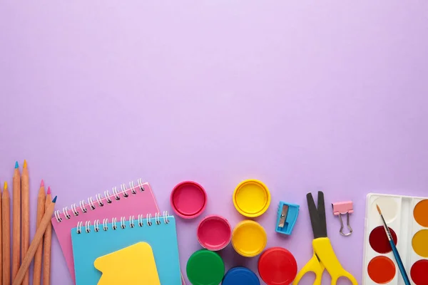 School supplies on purple background. Back to school concept. Top view.