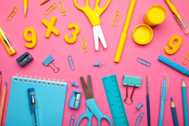 Okul malzemeleri pembe arka planda. Okul konseptine geri dönelim. Üst görünüm.