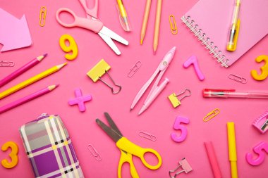 Okul malzemeleri pembe arka planda. Okul konseptine geri dönelim. Üst görünüm.