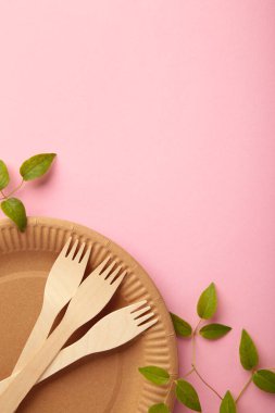 Pembe arka planda yeşil yapraklı tek kullanımlık çevre dostu yemekler. Sıfır atık, çevre dostu, plastikten arınmış. Üst görünüm