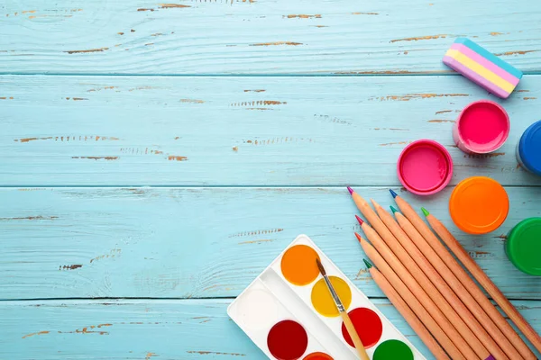 Mavi arka planda okul malzemeleri ve fotokopi alanı. Üst görünüm.