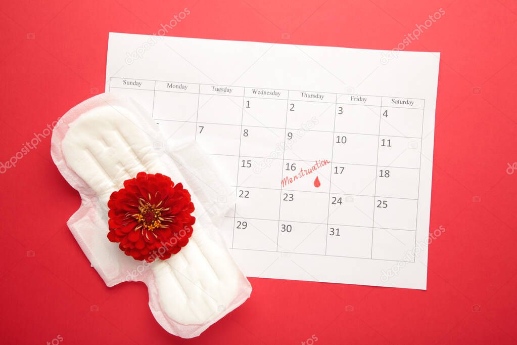 Menstruation calendar with pads on red background. Woman critical days, woman hygiene protection. Top view