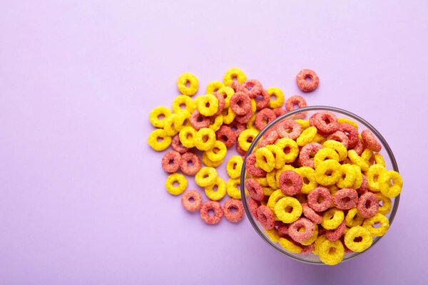 Multicolor cereals with fruity on purple background. Blank space for texts.