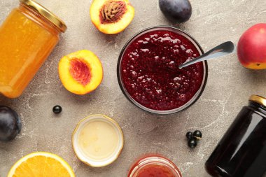 Gri arka planda kavanozda ev yapımı meyve reçeli.