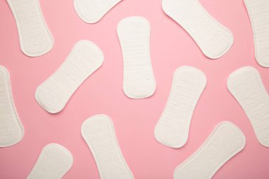 Adet döngüsü, kadın hijyeni ve koruması, pembe arka planda hijyenik ped, üst manzara, düz düzen.